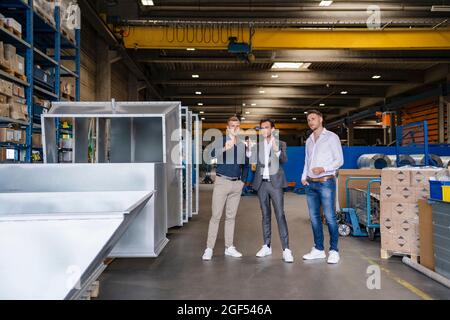 Businessman gesturing while explaining vision to colleagues at industry Stock Photo