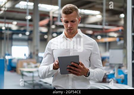 Young businessman using digital tablet at industry Stock Photo