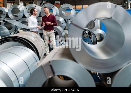 Male professionals discussing while working at industry Stock Photo