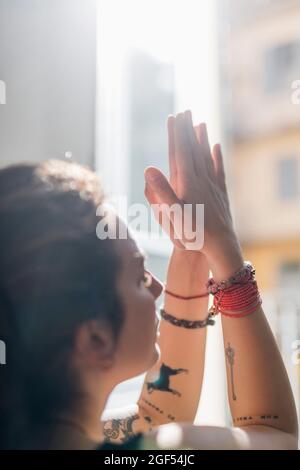 Woman with hands clasped practicing yoga in apartment Stock Photo