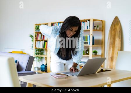 Pregnant female freelancer using laptop while working at home Stock Photo