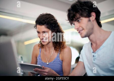 Man and woman using technologies in kitchen at home Stock Photo