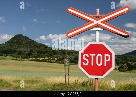 A red STOP sign before crossing the tracks, Czech Central Highlands. Stock Photo