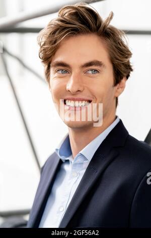 Smiling male professional looking away while contemplating Stock Photo