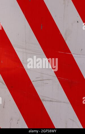 faded red and white diagonal stipes on flat steel sheet - caution road sign Stock Photo