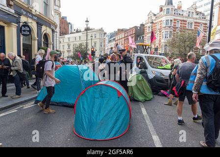London, UK. 23rd Aug, 2021. Protesters are seen erecting tents on the road during the Extinction Rebellion's day one of a two week demonstration in Central London.Extinction Rebellion held a protest against climate change, global warming, which plans to target the root cause of the climate and ecological crisis and to demand the government divest from fossil fuel companies ahead of COP26 the 2021 United Nations Climate Change Conference. (Photo by Dave Rushen/SOPA Images/Sipa USA) Credit: Sipa USA/Alamy Live News Stock Photo