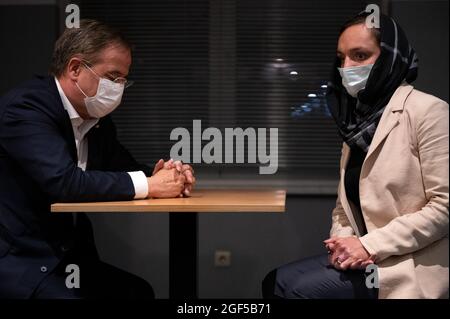 Duesseldorf, Germany. 23rd Aug, 2021. Women's rights activist Zarifa Ghafari (r), who fled Afghanistan, talks to Armin Laschet (CDU, l), Minister-President of North Rhine-Westphalia and the Union's candidate for Chancellor. The former mayor of the Afghan city of Maidan Shahr had reached Kabul airport under dramatic circumstances. From there she had been flown out via Islamabad to Istanbul and then landed at Cologne/Bonn Airport on Monday evening. Credit: Federico Gambarini/dpa/Alamy Live News