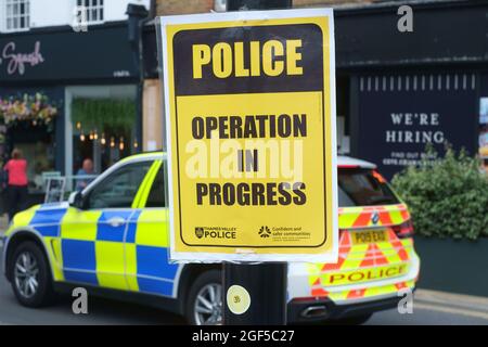 A yellow  'Police Operation in Progress' sign attached to a lamp post from Thames Valley Police Stock Photo