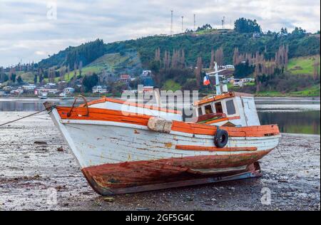 Fishing boat on dry land, Castro, Chiloe Island, Chile. Stock Photo