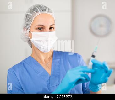 Nurse fills syringe with injection solution Stock Photo