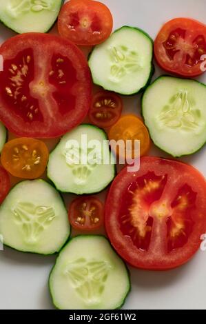 Slices of Cucumber and Tomatoes on White Background Stock Photo