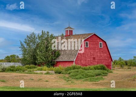 Vintage red barn in a farmyard on the prairies in Saskatchewan Stock Photo