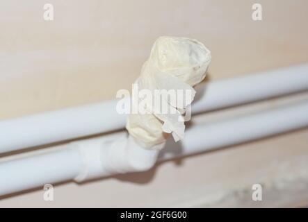 A close-up on a valve of central radiator heating pipes wrapped around with masking tape, painter's tape to keep it clean from plastering and finishin Stock Photo