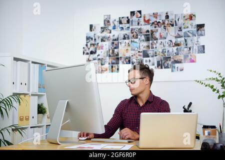 Portrait of serious young UI designer or art director working on project at his office desk Stock Photo