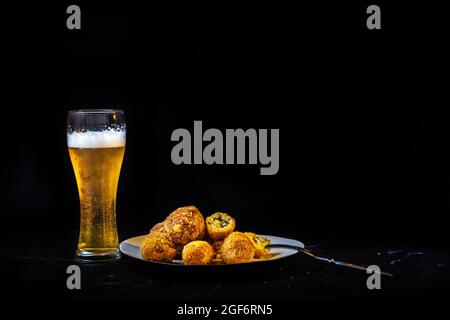 Premium Photo  Cheese balls with garlic and dill inside for a snack in a  plate on a black background.