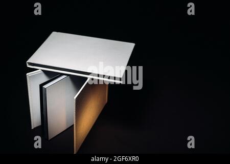 Composition of photo books in natural white leather of different sizes. The white paper on a dark background. Stock Photo