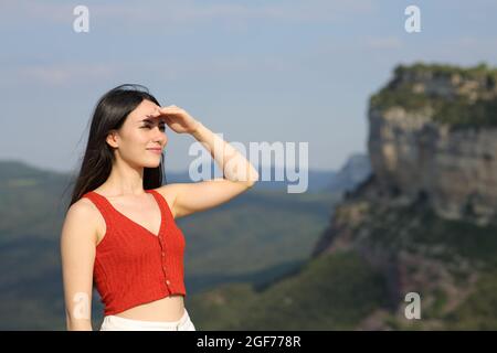 Asian woman looking forward protecting from sun with her hand in the mountain Stock Photo
