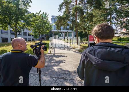 Darmstadt, Germany. 24th Aug, 2021. Media representatives stand in front of the building L201 on the campus Lichtwiese of the TU Darmstadt in the morning. The day before, six people had been brought to clinics here with symptoms of poisoning such as malaise and discoloration; a 30-year-old student was in a critical condition. Credit: Frank Rumpenhorst/dpa/Frank Rumpenhorst/dpa/Alamy Live News Stock Photo