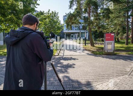Darmstadt, Germany. 24th Aug, 2021. Media representatives stand in front of the building L201 on the campus Lichtwiese of the TU Darmstadt in the morning. The day before, six people had been brought to clinics here with symptoms of poisoning such as malaise and discoloration; a 30-year-old student was in a critical condition. Credit: Frank Rumpenhorst/dpa/Frank Rumpenhorst/dpa/Alamy Live News Stock Photo
