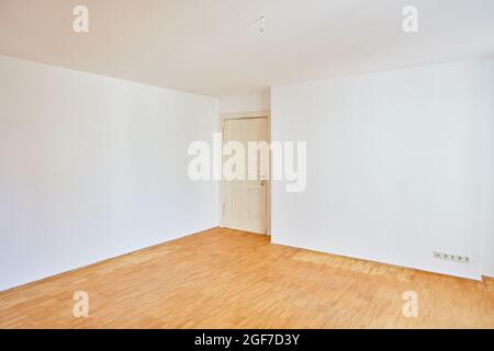 Corner with old building door in an empty room with parquet in the old building Stock Photo