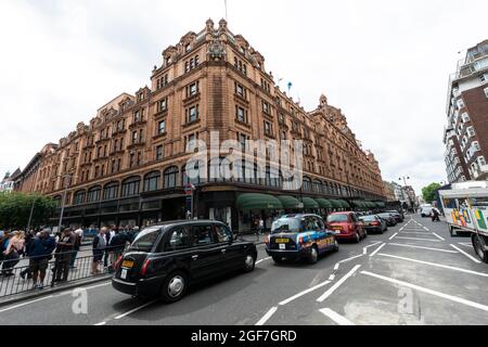 Taxis lined up on the street outside the luxury department stores, Harrods, London, England, United Kingdom Stock Photo