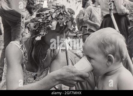 On the Cardiff to Greenham Common Peace March September 4th 1981. Ann Pettitt, one of the organisers, helps a baby, Tom Hall, drink from a cup.