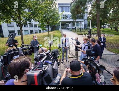 Darmstadt, Germany. 24th Aug, 2021. Chief Public Prosecutor Robert Hartmann (M) speaks to media representatives in front of building L201 on the Lichtwiese campus of the TU Darmstadt. The day before, six people had been brought to clinics here with symptoms of poisoning, a 30-year-old student was in critical condition. Attempted murder is now being investigated because of the suspected poison attack. Credit: Frank Rumpenhorst/dpa/Alamy Live News Stock Photo