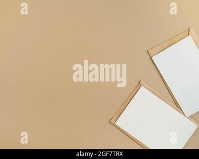 Two blank postcards and envelopes on beige background. Top view Stock Photo