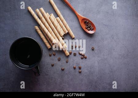 wafer roll chocolate, coffee beans and coffee on black  Stock Photo