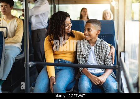 Beautiful smiling African American family going on a bus Stock Photo
