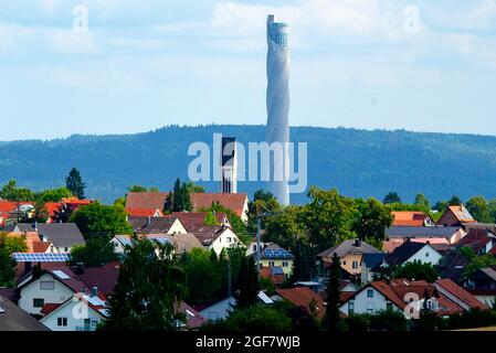 At 246 m (meters), the TK Elevator test tower towers over the church in the village ofzimmer ob Rottweil by far; the elevator test tower for express and high-speed elevators was built by Thyssenkrupp Elevator between 2014 and 2017; Recording from 08/13/2021; Stock Photo