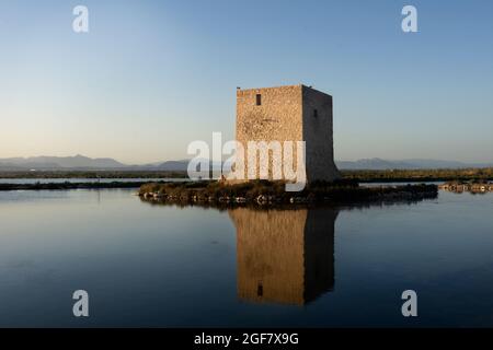 Sunset in the natural park of Salinas. In the foreground an old abandoned tower to collect salt. Above perched two seagulls. The building and part of Stock Photo