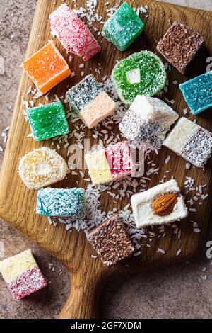 Turkish delight of different types on a wooden board, dark background, top view. Stock Photo