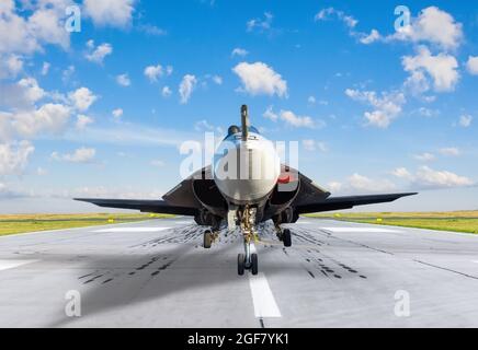 Black supersonic military fighter jet on the runway, ready to take off. Straight forward view Stock Photo