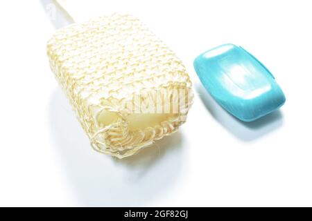 loofah body scrub with wooden handle and blue soap bar on white background Stock Photo