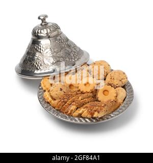 Traditional metal tajine with homemade Moroccan cookies isolated on white background Stock Photo