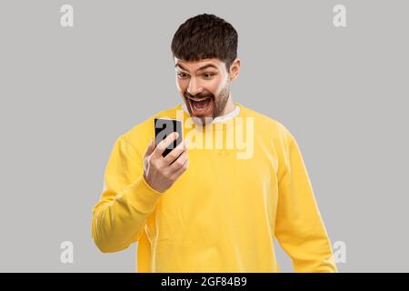 happy smiling young man with smartphone Stock Photo