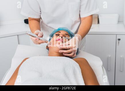 Beautician making mesotherapy treatment with dermapen on face of adult woman Stock Photo