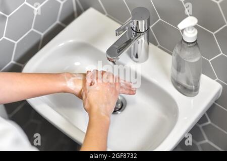 close up of woman washing hands with liquid soap
