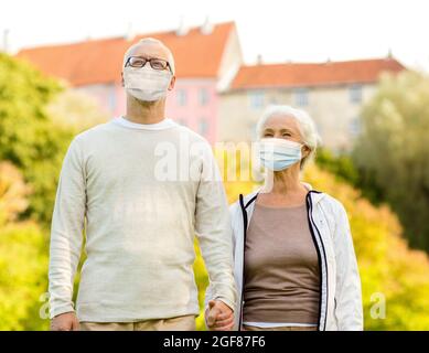 senior couple in protective medical masks outdoors Stock Photo
