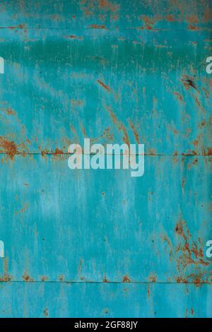 turquoise painted flat steel sheet with cracks and rust stains Stock Photo