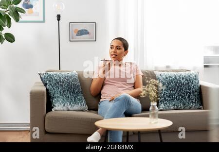 woman recording voice with smartphone at home Stock Photo