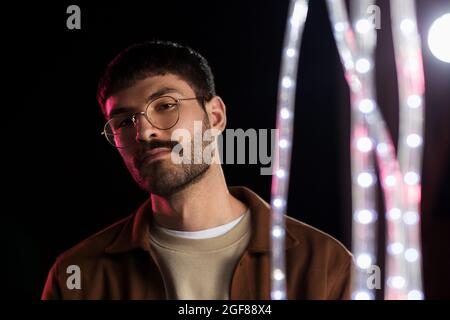 Luce al neon in bicchieri di un uomo. Ritratto futuristico cyber studio.  Techno bagliore e vibrante colore cyberpunk. Modello maschile con occhiali  da sole Foto stock - Alamy