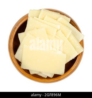 Thin Grana Padano cheese slices, in a wooden bowl. Italian hard cheese, similar to Parmesan, crumbly-textured, with strong savory flavor. Stock Photo