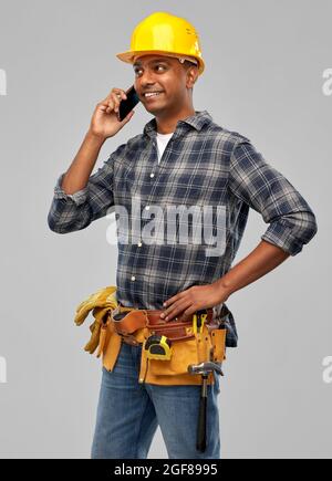 indian builder in helmet calling on smartphone Stock Photo