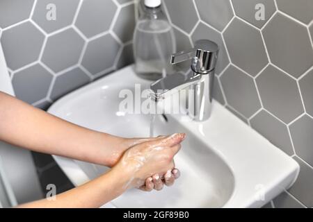 close up of woman washing hands with liquid soap