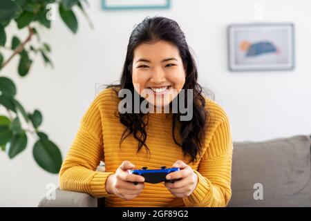 asian woman with gamepad playing game at home Stock Photo