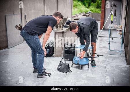 Behind the scene. Filmmaking lighting technician electric engineer adjusting and setup lights for movie film scene. Light Department. Film Crew Stock Photo