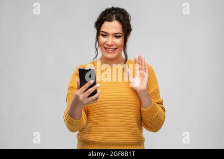 happy young woman having video call on smartphone Stock Photo