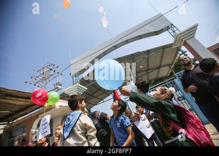 Gaza, Palestine. 24th Aug, 2021. Palestinian children launch balloons during an event to send humanitarian messages to the world to end the siege of Gaza by Israel. Credit: SOPA Images Limited/Alamy Live News Stock Photo